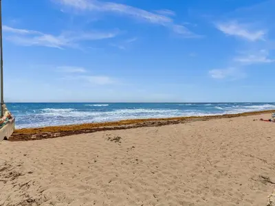 a sandy beach with the ocean in the background at Beachside 1BR in Hollywood | Parking + WiFi in Dania Beach