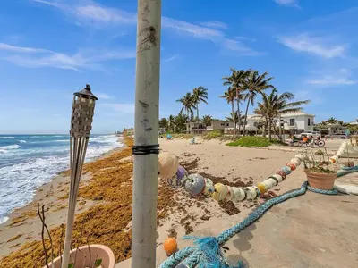 a pole on the beach next to the ocean at Beachside 1BR in Hollywood | Parking + WiFi in Dania Beach