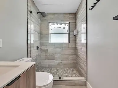 a bathroom with a shower with a toilet and a window at Dania Beach 1BR | Views + WiFi + Parking in Dania Beach