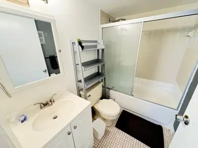 a bathroom with a sink and a toilet and a mirror at South Beach and Collins, Parking included in Miami Beach