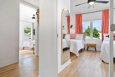 a white bedroom with a bed and a mirror at Havana Oh Na Na Unit A in Miami