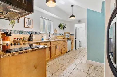 a kitchen with wooden cabinets and a tile floor at Havana Oh Na Na Unit A in Miami