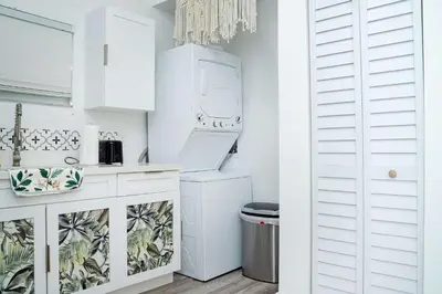 a kitchen with white cabinets and a washer and dryer at Havana Oh Na Na Unit C in Miami