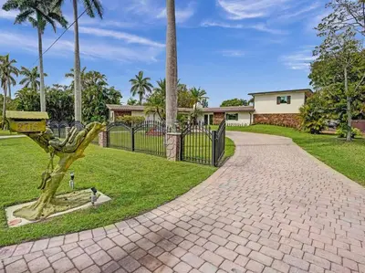 a brick walkway in front of a wrought iron fence at Villa Riverland in Fort Lauderdale