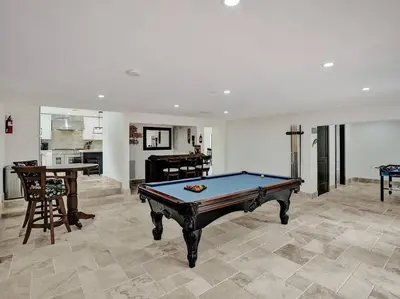 a living room with a pool table and a kitchen at Villa Riverland in Fort Lauderdale