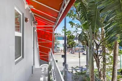a balcony of a building with a palm tree at Alton Rd By At Mine Hospitality in Miami Beach