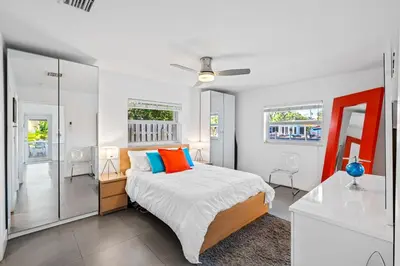 a bedroom with a large bed with orange and blue pillows at Waterfront Oasis with Pool, Sunset Views and Dock in Fort Lauderdale
