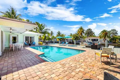 a swimming pool with a patio and a house at Waterfront Oasis with Pool, Sunset Views and Dock in Fort Lauderdale