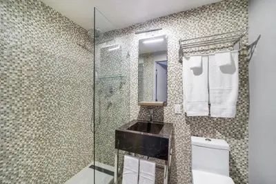 a bathroom with a glass shower and a toilet at Alamo Hotel in Miami Beach