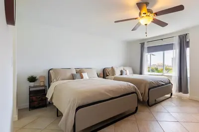 a bedroom with two beds and a ceiling fan at Tiny Tower Treasure - Sleeps 5 & Soaks Sun in Sunny Isles Beach