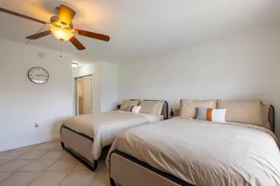 two beds in a room with a ceiling fan at Tiny Tower Treasure - Sleeps 5 & Soaks Sun in Sunny Isles Beach