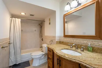 a bathroom with a sink and a toilet and a mirror at Tiny Tower Treasure - Sleeps 5 & Soaks Sun in Sunny Isles Beach