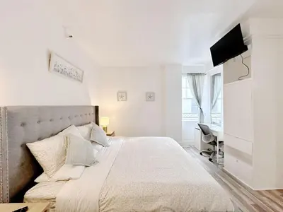 a white bedroom with a large bed and a desk at Pool and Jacuzzi. Walk to beach, South Point Pier in Miami Beach