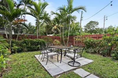 a patio table and chairs in a yard at 2 Bedroom Cozy House Near Barry University in Miami