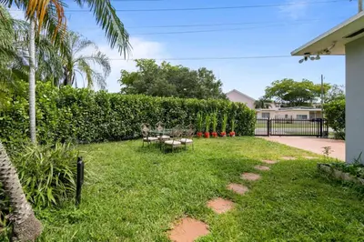 a patio with a table and benches in a yard at 2 Bedroom Cozy House Near Barry University in Miami