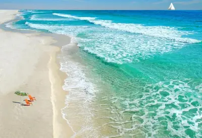 a beach with an umbrella and a chair and the ocean at Right on the beach, Ocean Drive Secured Condo in Miami Beach