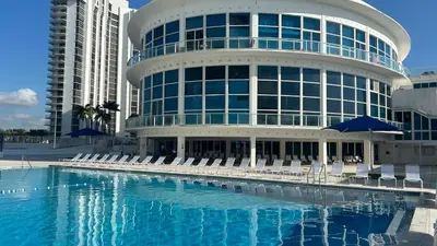 a large building with chairs and a swimming pool at Shine Suites Balcony Duplex 5 in Miami Beach