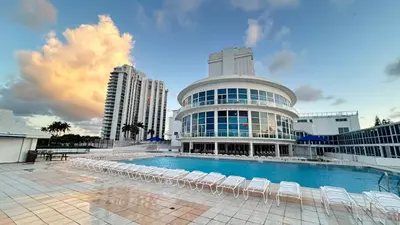 a large building with chairs and a swimming pool at Shine Suites Balcony Duplex 5 in Miami Beach