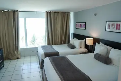a hotel room with two beds and a window at Shine Suites Balcony Duplex 5 in Miami Beach