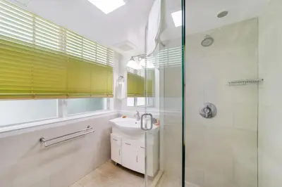 a bathroom with a glass shower and a sink at Villa Italia by At Mine Hospitality in Miami Beach