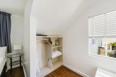 a bedroom with white walls and a window and a bed at Villa Italia by At Mine Hospitality in Miami Beach