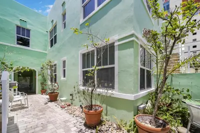 a green building with potted plants in a courtyard at Villa Italia by At Mine Hospitality in Miami Beach