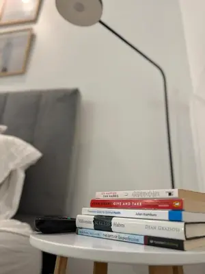 a stack of books on a table with a lamp at South of Fifth Oceanfront condo with Beach Perks! in Miami Beach