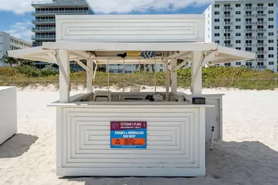a white kiosk on the beach with a building at South of Fifth Oceanfront condo with Beach Perks! in Miami Beach