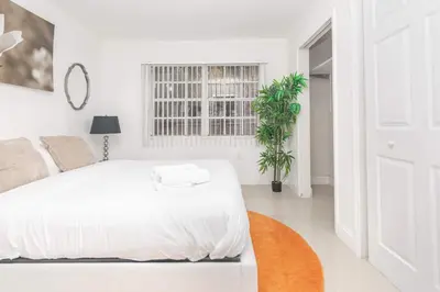 a white bedroom with a white bed and a window at Charming 3BR Getaway - Central Miami Location in Miami