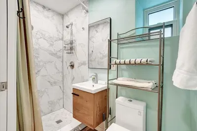 a bathroom with a shower and a sink and a toilet at Charming Beachside Studio - Steps to the Beach in Hollywood