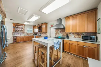 a large kitchen with wooden cabinets and a white island at Hollywood Beach Bliss Villa Sleeps 10 in Hollywood