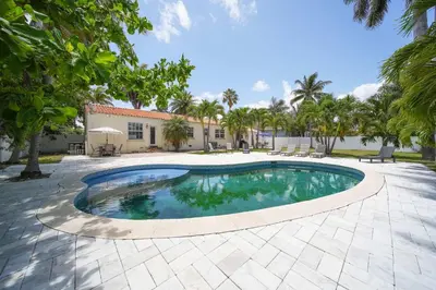 a swimming pool in a courtyard with trees and a building at Hollywood Beach Bliss Villa Sleeps 10 in Hollywood