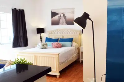 a bedroom with a white bed with blue and pink pillows at Light-Filled Apt Steps to Beach Convention Center in Miami Beach