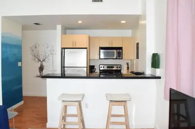 a kitchen with a counter and two bar stools at Light-Filled Apt Steps to Beach Convention Center in Miami Beach