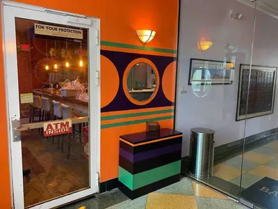 a room with a restaurant with a table and a mirror at Right on the Beach Ocean Dr Secured Condo 206 in Miami Beach
