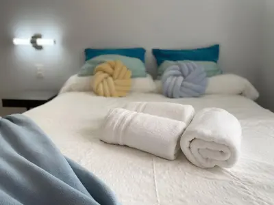 a white bed with towels and pillows on it at Right on the Beach Ocean Dr Secured Condo 206 in Miami Beach
