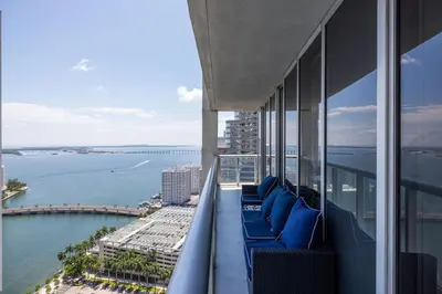 a balcony with blue chairs and a view of the water at Wrap around Bay View, W Hotel Luxury 2BR 2BA, Pool, Spa, Free Gym Classes in Miami