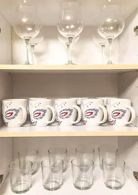 a shelf filled with cups and wine glasses at Top Stay Miami Gold Brickell in Miami