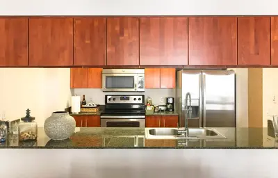 a kitchen with stainless steel appliances and wooden cabinets at Top Stay Miami Gold Brickell in Miami
