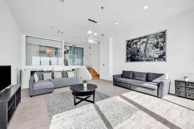 a living room with a couch and a tv at Shine Suites Balcony Duplex 11 in Miami Beach