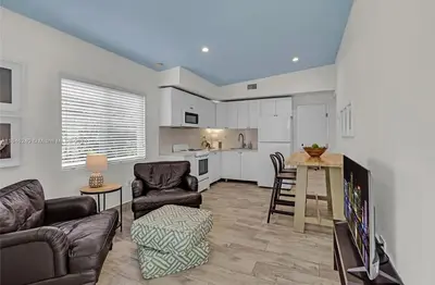 a living room with a couch and chairs and a kitchen at Avocado House in Miami