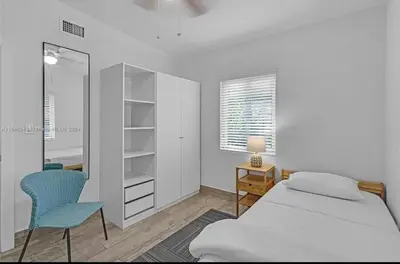 a bedroom with a bed and a desk and a mirror at Avocado House in Miami