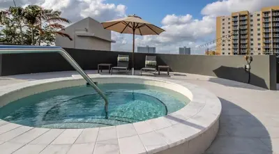 a small pool with an umbrella on top of a building at 2Bedroom 2 Bath condo 10 Mins Walking To Jackson Memorial Hospital in Miami