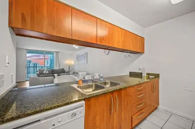 a kitchen with a sink and a living room at Skyline and Bay Glimpse 1BR Brickell Retreat in Miami