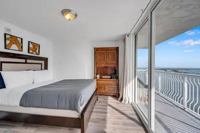 a bedroom with a bed and a balcony with the ocean at Panoramic 2BR Bay-View in Brickell With Parking in Miami
