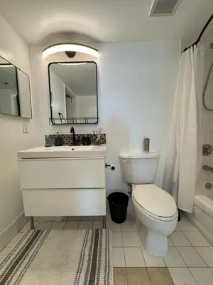 a bathroom with a toilet and a sink and a mirror at Elegant 1BR Condo at Brickell in Miami