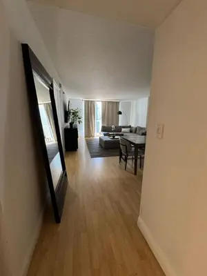 a hallway of a living room with a table and a mirror at Elegant 1BR Condo at Brickell in Miami