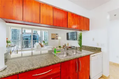 a kitchen with a sink and a living room at Awesome 4BR APT at Brickell in Miami