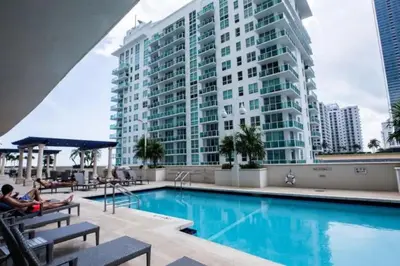 a hotel swimming pool with a large building in the background at Awesome 4BR APT at Brickell in Miami