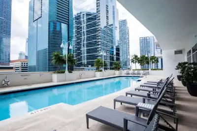 a pool with chairs and a view of the city at Lovely 2BR in the Heart of Brickell Free Parking in Miami
